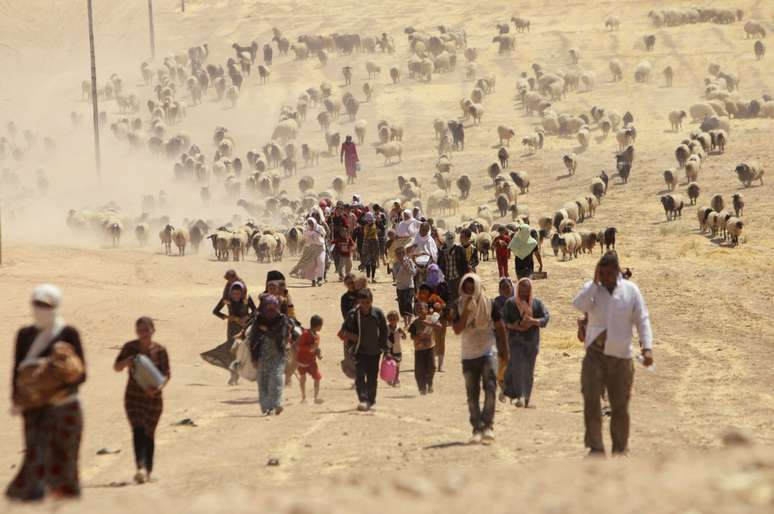 <p>Deslocados da minoria Yazidi fogem&nbsp;da viol&ecirc;ncia das for&ccedil;as leais ao Estado Isl&acirc;mico na cidade de&nbsp;Sinjar, em 10&nbsp;de agosto</p>