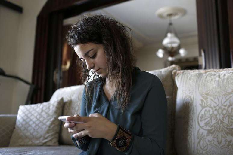 Farah Baker usa o telefone para tuitar dentro de casa na Cidade de Gaza. 10/08/2014