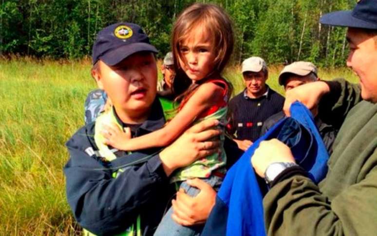<p>Karina Chikitova é carregada por um socorrista após passar 11 dias sozinha em um floresta infestada de ursos e lobos, na Sibéria</p>