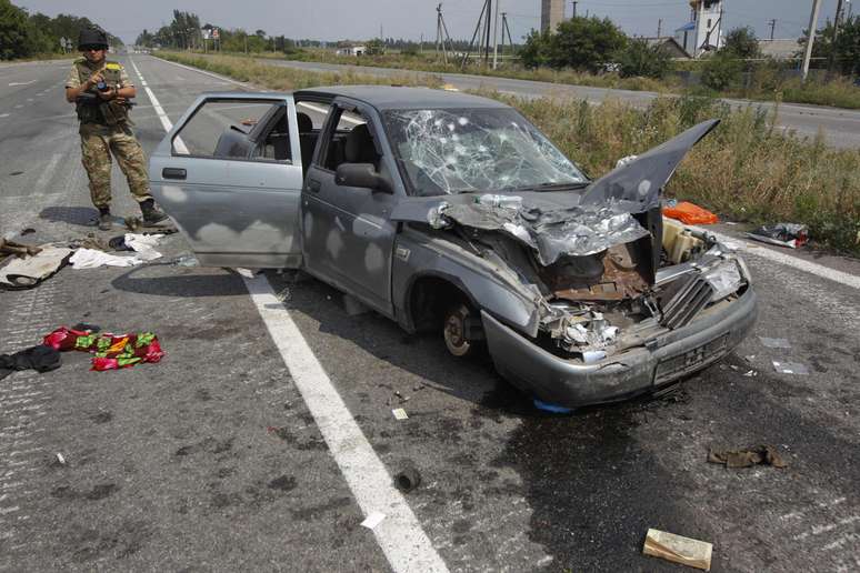 <p>Um soldado ucraniano &eacute; visto ao lado de um carro destru&iacute;do em um posto de controle perto de Donetsk, nesta segunda-feira, 11 de agosto</p>