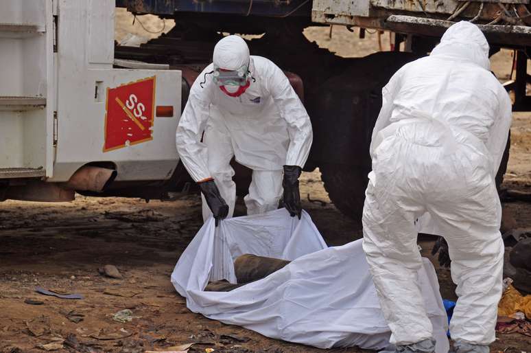 <p>Agentes de saúde removem o corpo de uma vítima do ebola em um centro para tratamento da doença na Libéria</p>