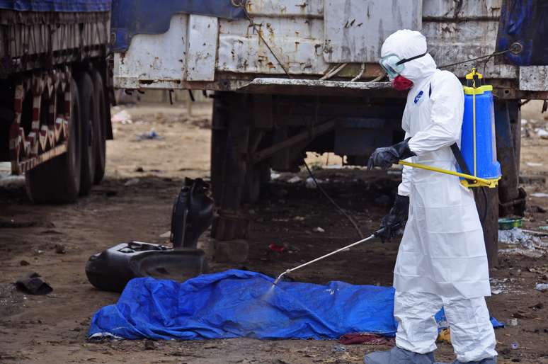 <p>O corpo de um homem encontrado na rua, com suspeita de morte pelo vírus ebola é pulverizado com desinfetante, em Monrovia, Libéria, em 12 de agosto</p>