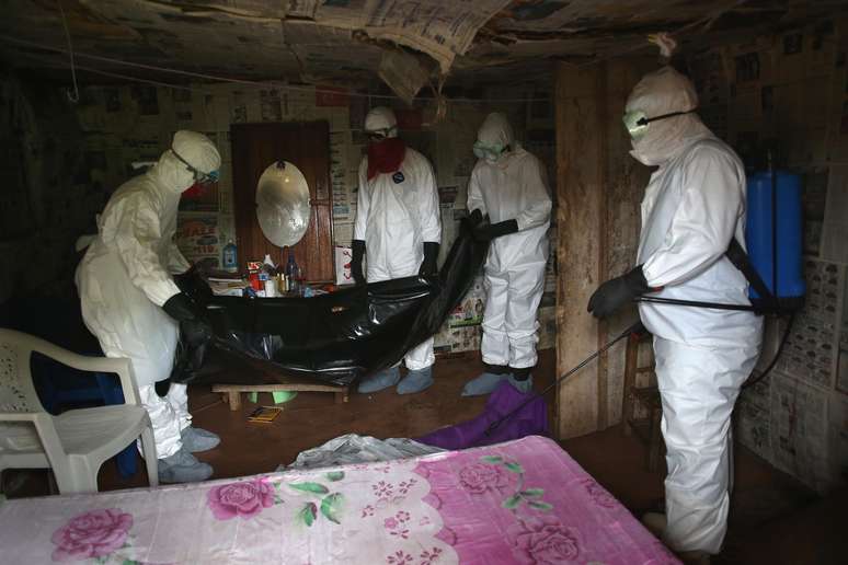 Agentes de saúde, na Libéria, retiram corpo de uma das milhares de vítimas do vírus Ebola