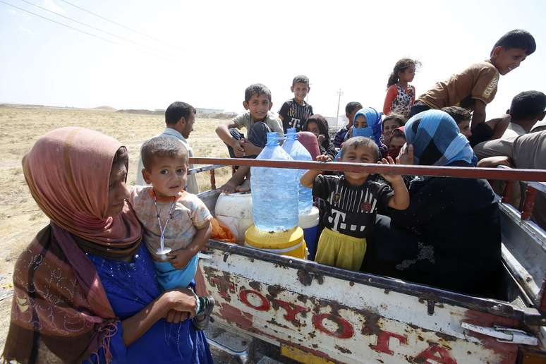 <p>Deslocados da minoria Yazidi&nbsp;que fugiram da viol&ecirc;ncia em&nbsp;Gwer, aguardam&nbsp;para voltar &agrave; cidade iraquiana em um ponto de verifica&ccedil;&atilde;o em 18 de agosto&nbsp;</p>