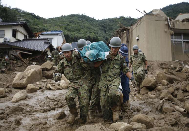 <p>Soldados das forças de autodefesa procuram por sobreviventes após um deslizamento de terra ter varrido uma área residencial em Hiroshima, oeste do Japão, em 20 de agosto</p>