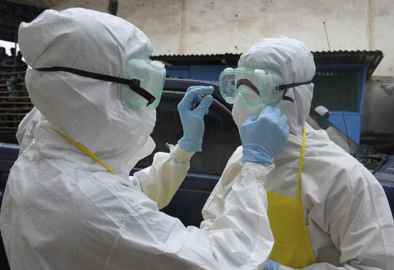 <p>Agentes de sa&uacute;de se preparam para remover&nbsp;um cad&aacute;ver abandonado com sintomas de ebola no mercado Duwala em Monrovia, capital da Lib&eacute;ria, em 17 de agosto</p>