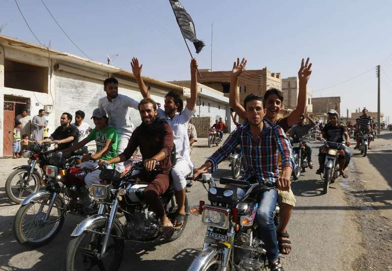 Moradores da cidade de Tabqa comemoram a tomada da base aérea pelo Estado Islâmico nesta segunda-feira