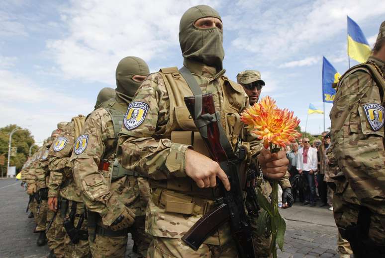 Soldado segura flor durante cerimônia na Ucrânia