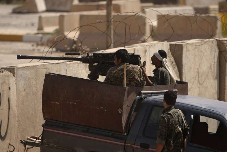 <p>Tropas curdas tomam&nbsp;posi&ccedil;&atilde;o atr&aacute;s de blocos de cimento na cidade iraquiana de Rabia, na fronteira do Iraque com a&nbsp;S&iacute;ria, durante confrontos com militantes do Estado Isl&acirc;mico, em 29 de agosto</p>