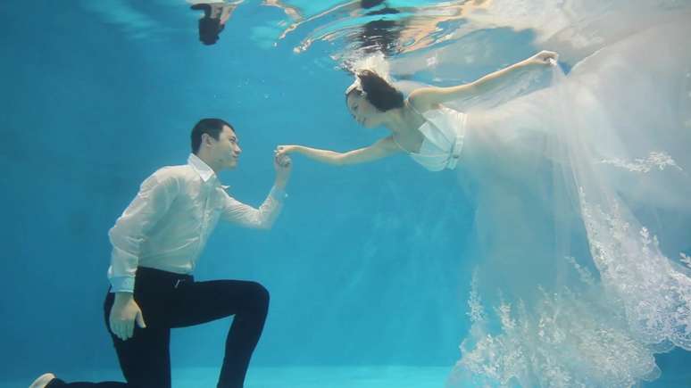 <p>As noivas são aconselhadas a usar roupas longas que flutuem sob a água</p>