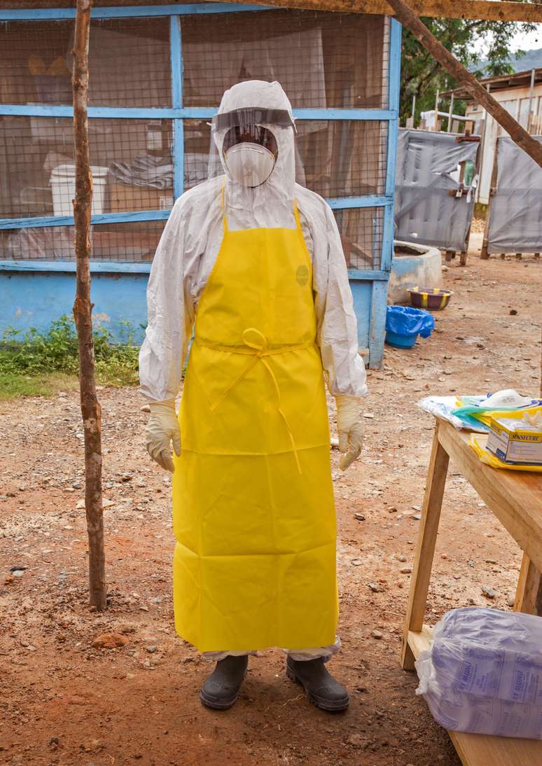 Agente de saúde veste roupa para entrar em centro de tratamento em Serra Leoa