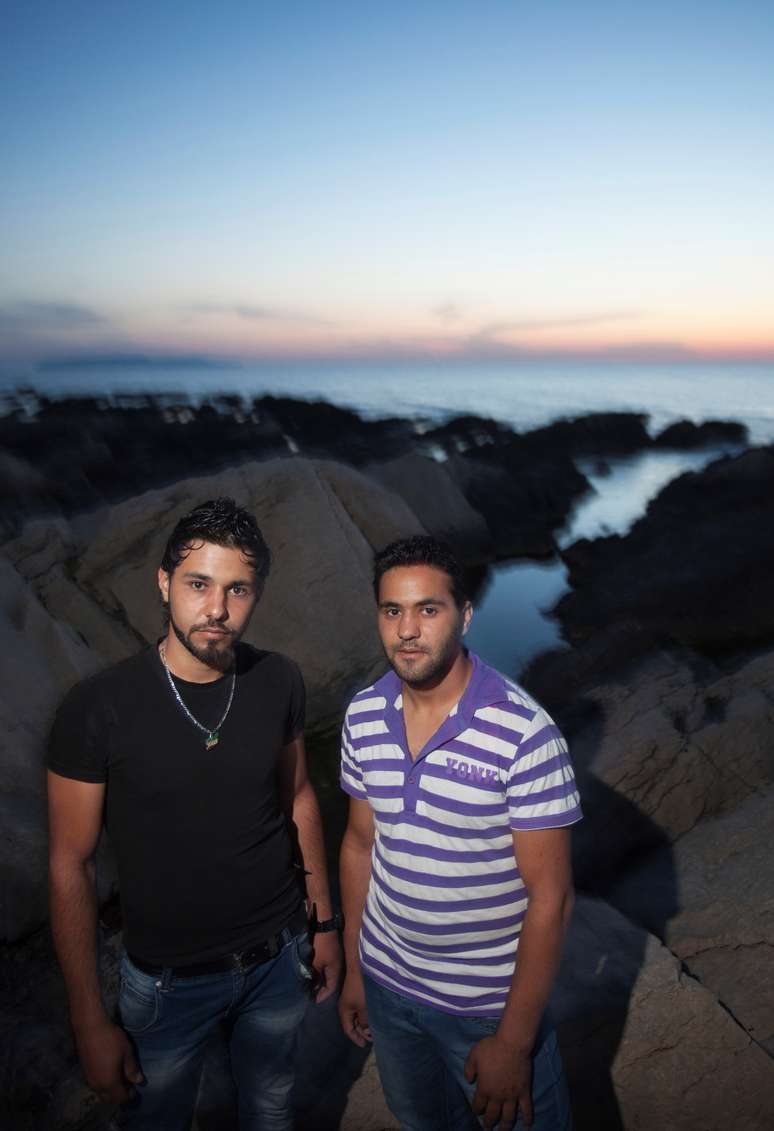 <p>Os irmãos e refugiados sírios Thamer e Thayer posam em frente à costa no oeste da Sicília</p>