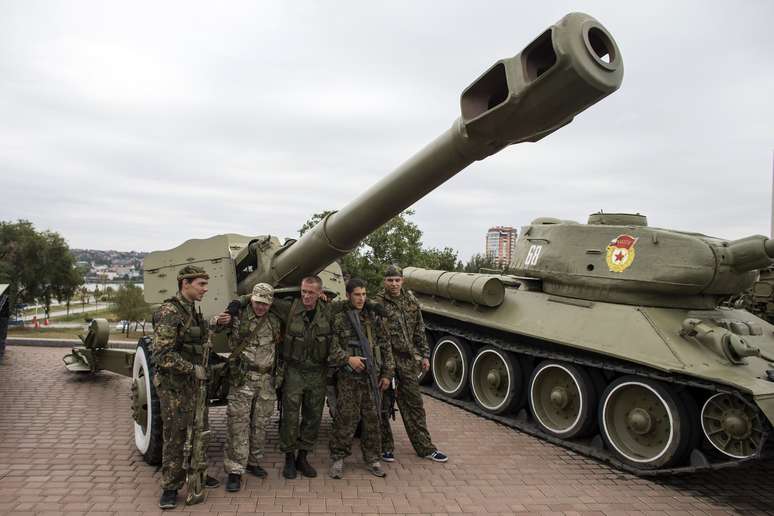 Militantes pró-russos fazem pose ao lado de tanque na cidade de Donetsk, leste da Ucrânia