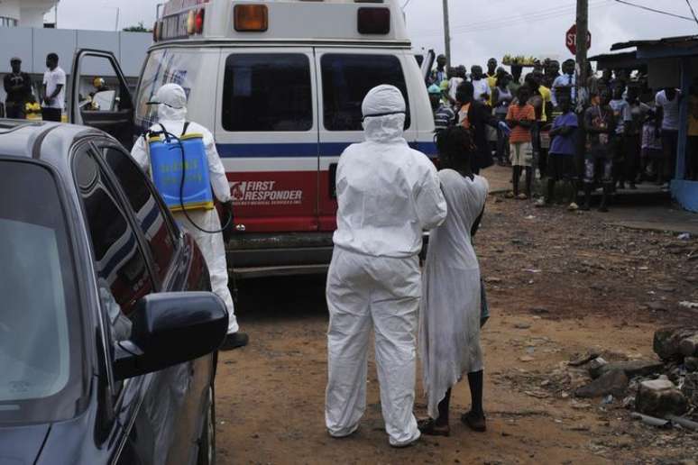 <p>Trabalhadores levam mulher suspeita de estar com Ebola para ambulância em Monróvia</p>