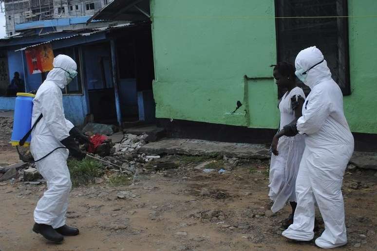 <p>Agentes de saúde higienizam, com  produtos químicos, uma mulher suspeita de ter contraído ebola em Monróvia</p>