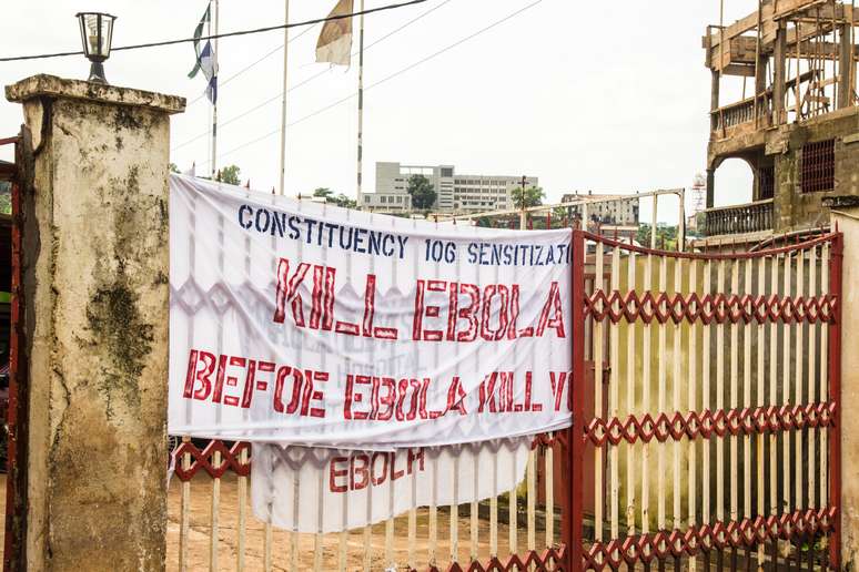 <p>Faixa amarrada a um portão na cidade de Freetown, Serra Leoa, traz a seguinte mensagem: "Mate o ebola, antes que ele te mate"</p>