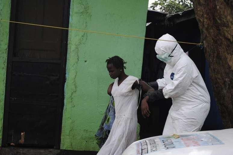 <p>Agente de saúde ajuda paciente com ebola na Libéria</p>