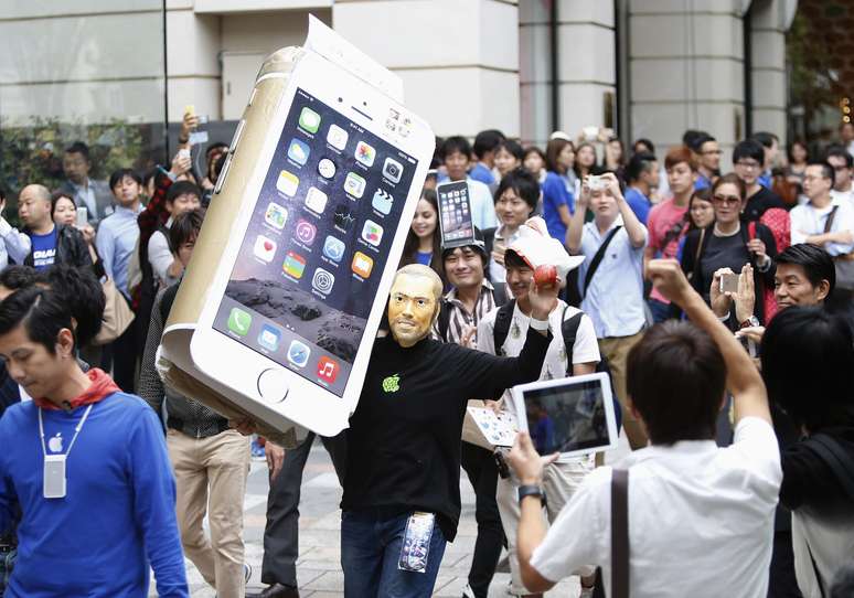 No Japão, humor deu o tom da fila de espera; homem com máscara do Steve Jobs passeia com um iPhone 6 “gigante” de papelão nas ruas de Tóquio 