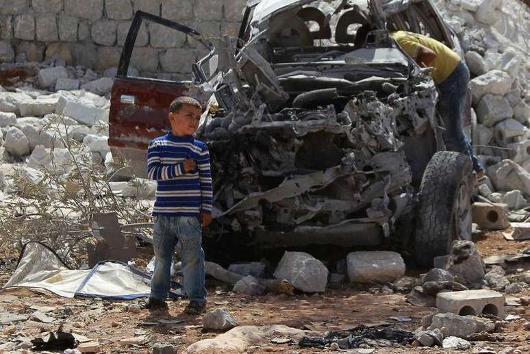 <p>Meninos observam carro destruído por ataque aéreo de terça-feira dos EUA em Kfredrian, na Síria, segundo ativistas</p>