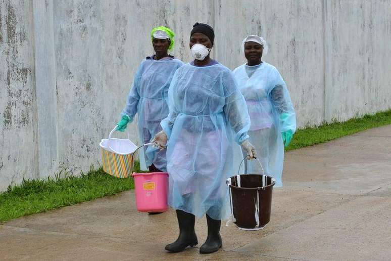 <p>Trabalhadores de saúde levam baldes com desinfetante em nova clínica para tratamento de Ebola em Monróvia, na Libéria</p>