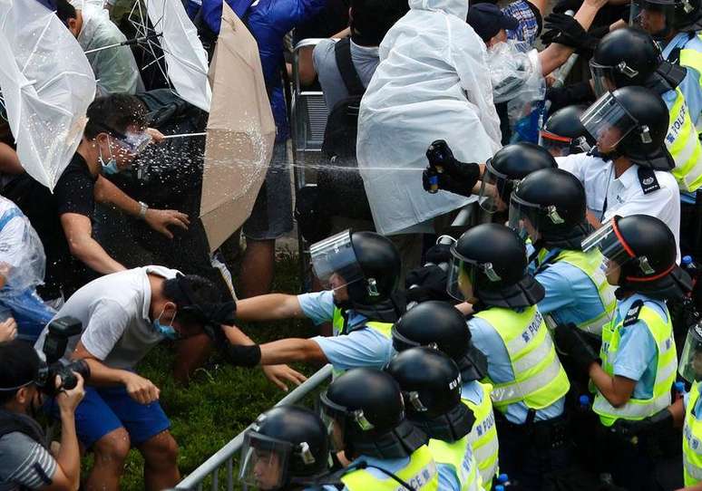 <p>Manifestantes com guarda-chuvas bloqueiam rua perto da sede do governo de Hong Kong</p>