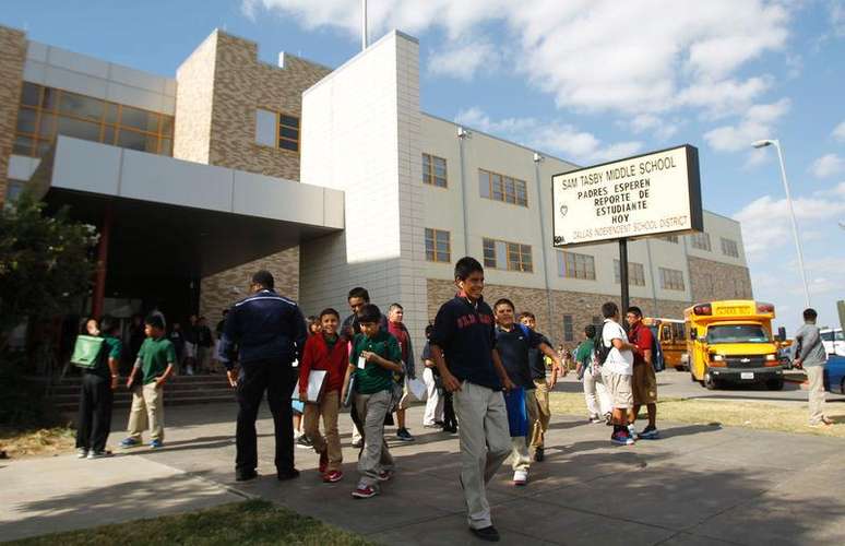 Alunos deixam o colégio Tasby Middle School, onde um estudante que esteve em contato com um homem diagnosticado com Ebola foi removido da instituição em Dallas, Estados Unidos, na quarta-feira. 01/10/2014