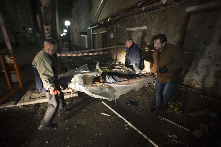 Homens retiram corpo de vítima da Cruz Vermelha que morreu na Ucrânia nesta quinta-feira