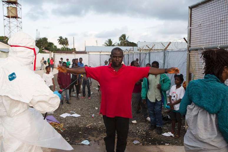 <p>Paciente é desinfetado ao deixar clínica em Monróvia, Libéria, para tratamento de pessoas com ebola</p>