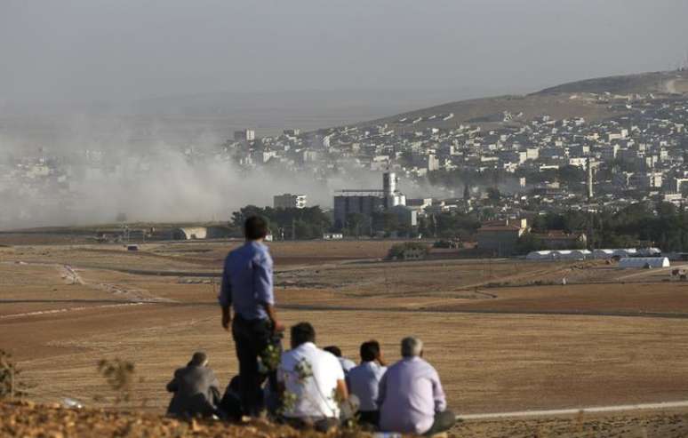 <p>Curdos turcos observam a cidade s&iacute;ria curda de Kobani do topo de uma colina perto da fronteira entre Turquia e S&iacute;ria, na regi&atilde;o do port&atilde;o de Mursitpinar, em 10 de outubro</p>