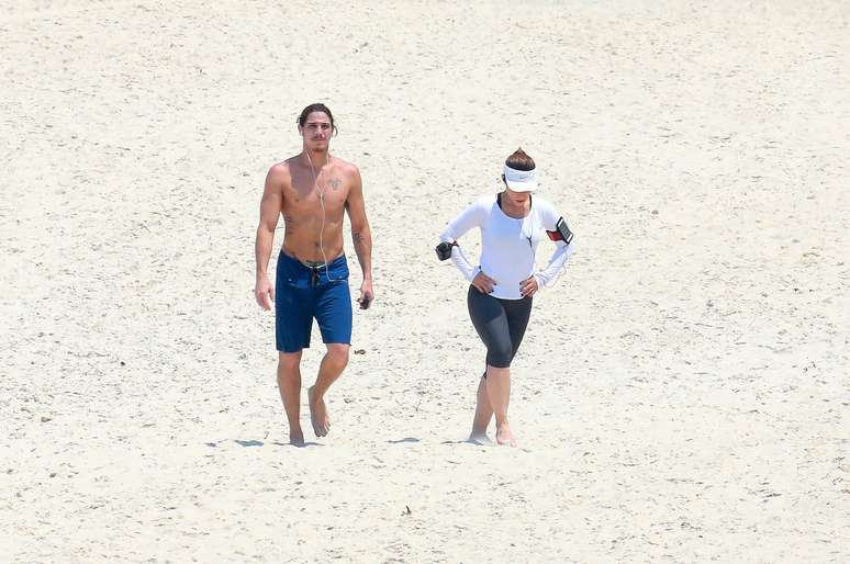 Cléo Pires e Rômulo Neto caminham na praia