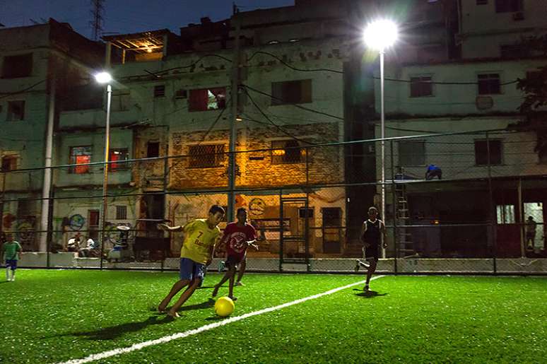 Jovens jogam em campo de futebol com energia elétrica criada por meio de placas que captam cinética no Morro da Mineira