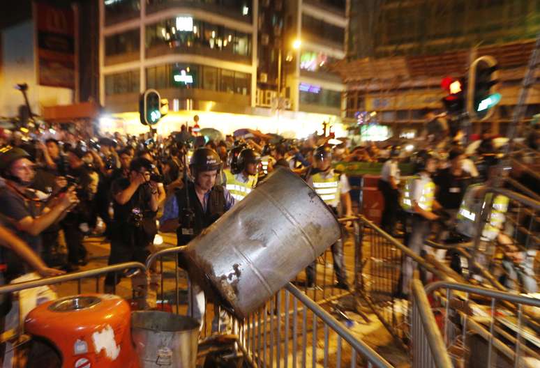 <p>Policiais retiram as barreiras montadas pelos manifestantes na área ocupada no bairro de Mong Kok, na madrugada de 18 de outubro</p>