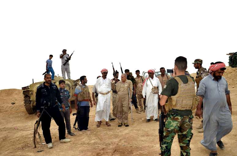 <p>Forças de segurança iraquianas e combatentes tribais se reúnem para defender a cidade iraquiana de Haditha, 240 km a noroeste de Bagdá, frente ao avanço do grupo extremista Estado Islâmico que controla de quase um terço do país</p>