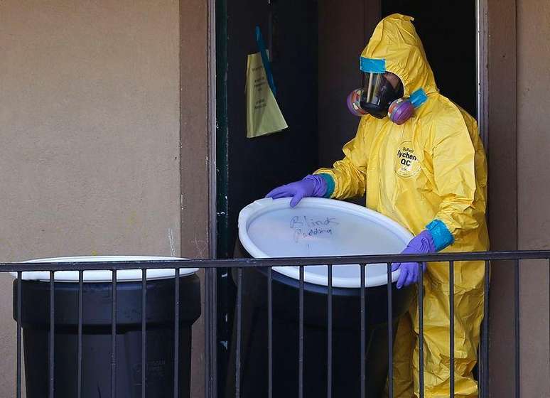 <p>Profissional de descontaminza&ccedil;&atilde;o com roupa especial de prote&ccedil;&atilde;o remove material de apartamento onde morava homem diagnosticado com Ebola em Dallas, no Texas</p>