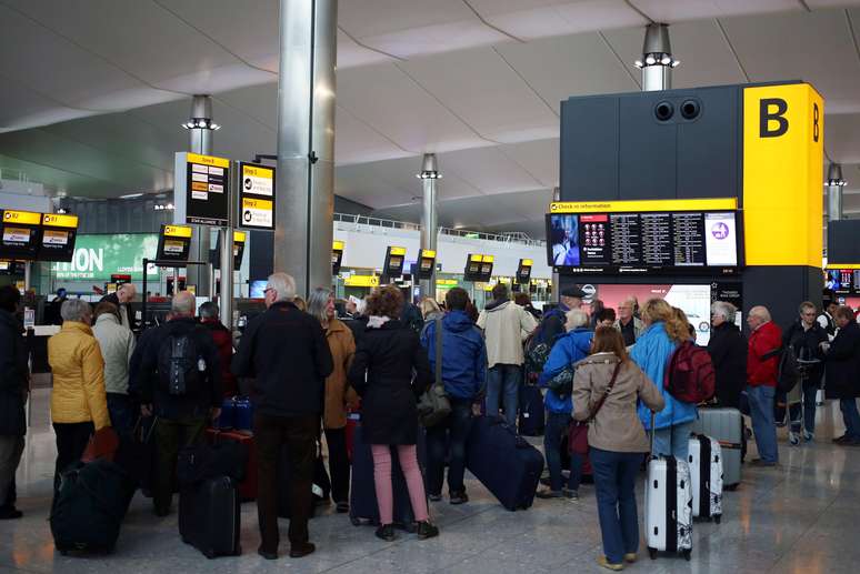 Pessoas fazem filas enquanto aguardam no aeroporto de Heathrow, em Londres, após voos serem cancelados