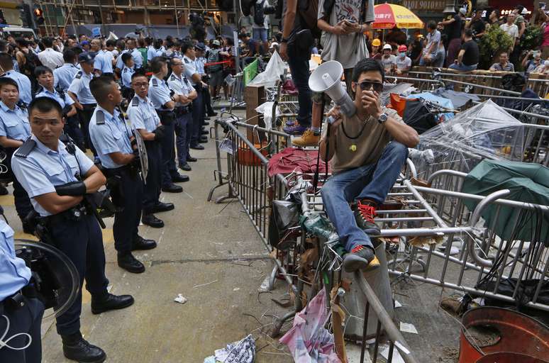 <p>Um manifestante tenta impedir&nbsp;taxistas de removerem&nbsp;barricadas montadas&nbsp;em uma &aacute;rea ocupada&nbsp;no bairro de Mong Kok, em Hong Kong, em 22 de outubro</p>