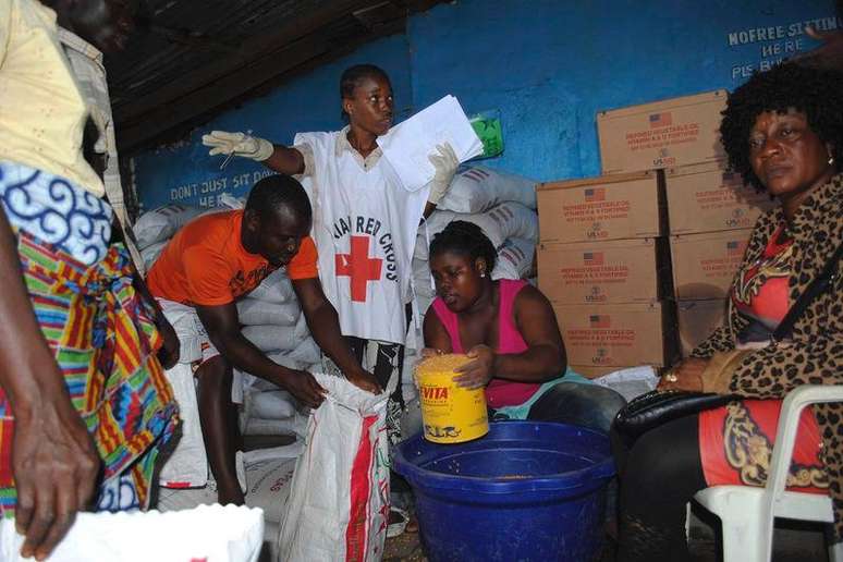 <p>Trabalhadores da Cruz Vermelha distribuem alimentos em Monróvia, na Libéria, um dos países mais afetados pelo surto de Ebola na África Ocidental</p>