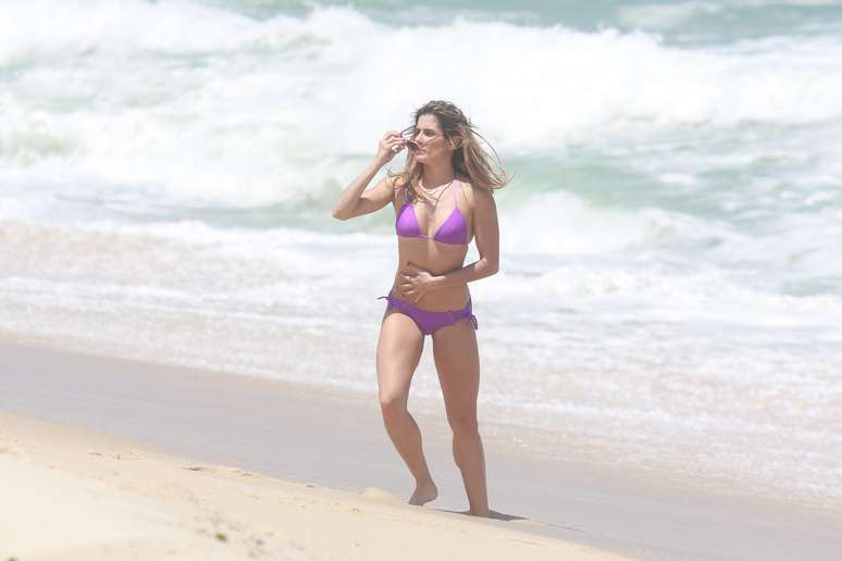 Deborah Secco e Rodrigo Simas trocaram vários beijos nesta quinta-feira (23) durante a gravação da novela Boogie Oogie, da trama das 18h, na praia da Macumba, no Rio de Janeiro. A atriz esbanjou sua boa forma ao exibir o biquíni que vestia quando entrou no mar.