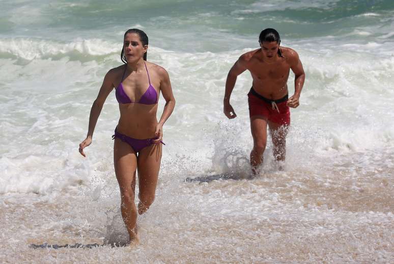 Deborah Secco e Rodrigo Simas trocaram vários beijos nesta quinta-feira (23) durante a gravação da novela Boogie Oogie, da trama das 18h, na praia da Macumba, no Rio de Janeiro. A atriz esbanjou sua boa forma ao exibir o biquíni que vestia quando entrou no mar.