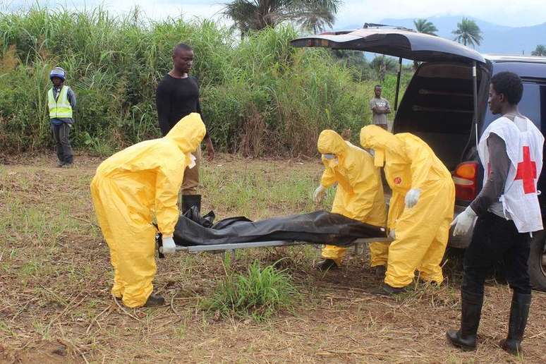 <p>Agentes de saúde carregam corpo de vítima do ebola em Freetown, na Serra Leoa, dia 21 de outubro</p>