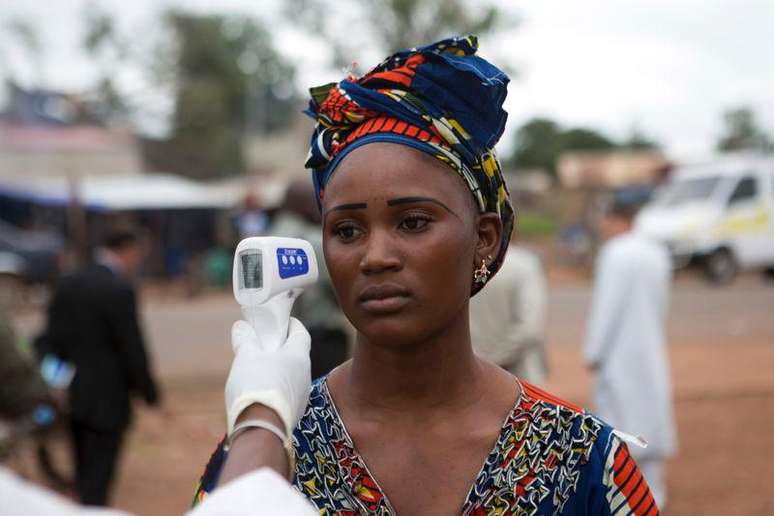 <p>Agente de saúde checa temperatura de uma mulher que entra no Mali, vindo do Guiné. A OMS disse que está enviando especialistas ao país, que teve primeiro caso confirmado nesta quinta-feira</p>