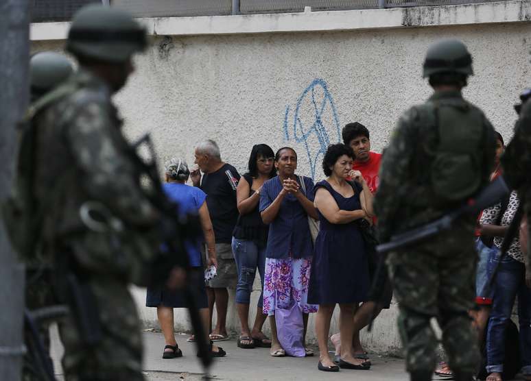 Soldados fazem a segurança em porta de colégio no Complexo da Maré, Rio de Janeiro