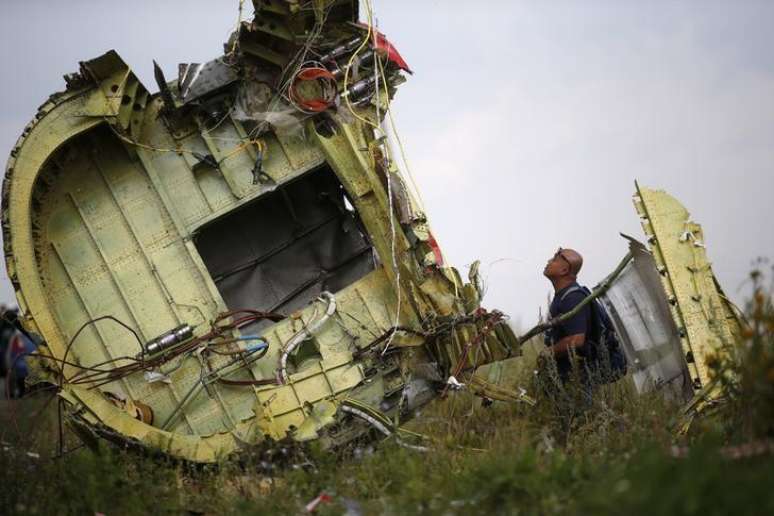 <p>Investigador observa destro&ccedil;os do avi&atilde;o que caiu perto de Grabovo, leste da Ucr&acirc;nia</p>