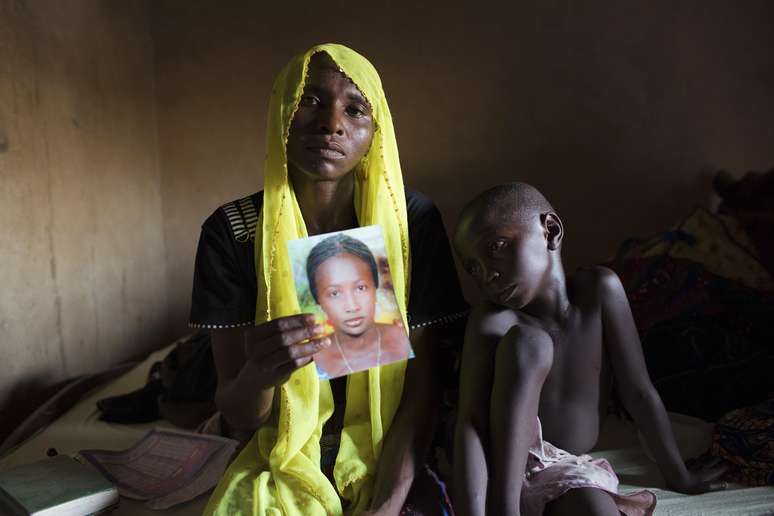 <p>Uma mulher mostra a foto da filha, sequestrada em maio de 2014 pelo Boko Haram em Maiduguri</p>