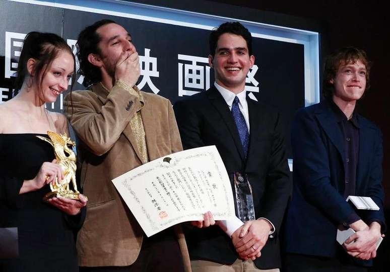 Diretor Josh Safdie (D) recebe prêmio do Festival de Tóquio junto ao seu irmão Benny Safdie nesta sexta-feira. Na foto também estão os atores Arielle Holmes (E) e Caleb Landry Jones .