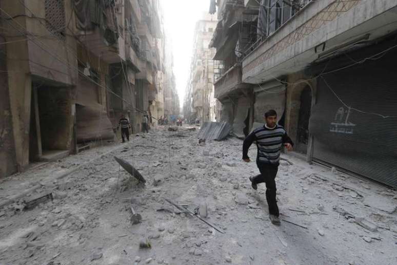 <p>Homem corre num local atingido por um suposto ataque de forças leais ao presidente sírio, Bashar al-Assad, num bairro de Aleppo, na Síria</p>