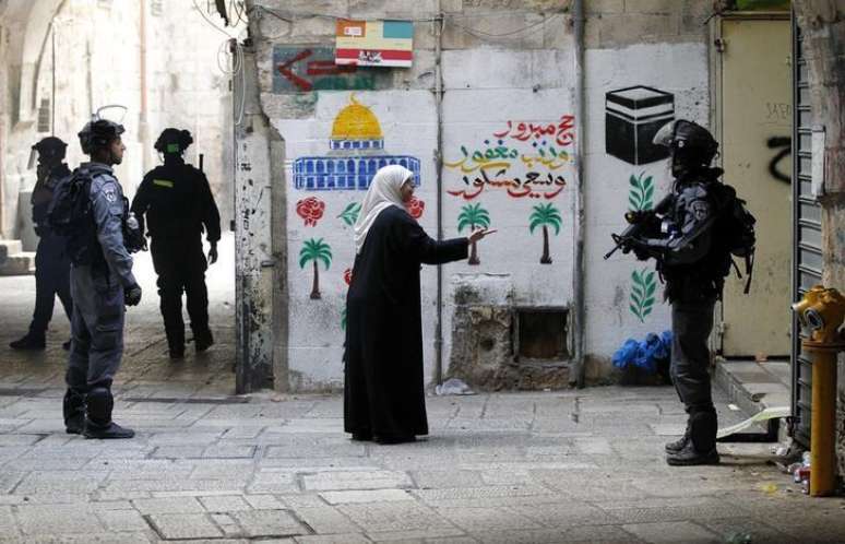 <p>Palestina gesticula para um policial israelense na cidade velha de Jerusal&eacute;m</p>
