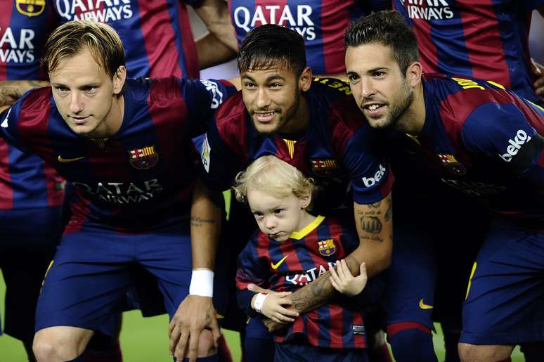 <p>Ao lado do pai, Davi Lucca posa para foto com time do Barcelona</p>