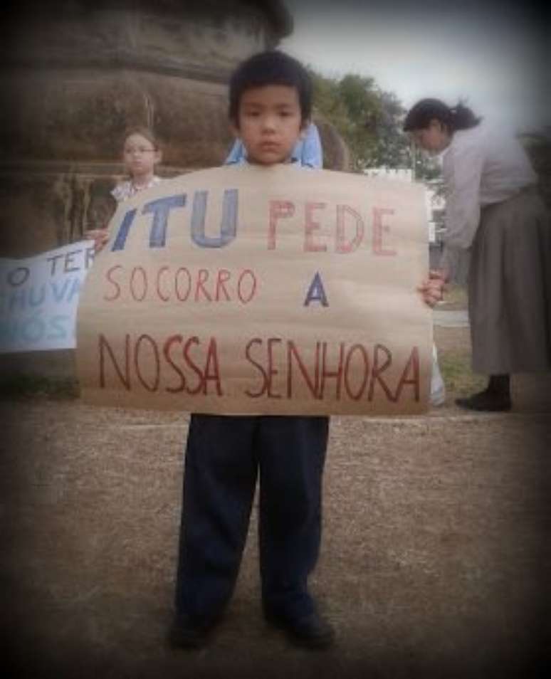 Menino leva cartaz na reza pela água em Itu