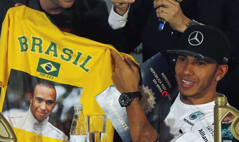 Hamilton exibe camisa e passaporte que ganhou